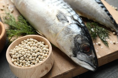 Photo of Fresh raw mackerels and spices on table, closeup. Seafood delicacies
