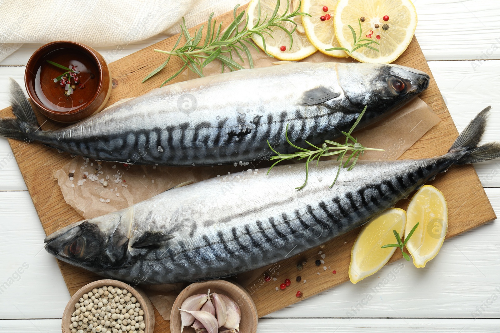 Fresh raw mackerels and spices on white wooden table, flat lay. Seafood delicacies Photo of Fresh raw mackerels and spices on white wooden table, flat lay. Seafood delicacies