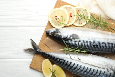 Photo of Seafood delicacies. Fresh raw mackerels and spices on white wooden table, flat lay. Space for text