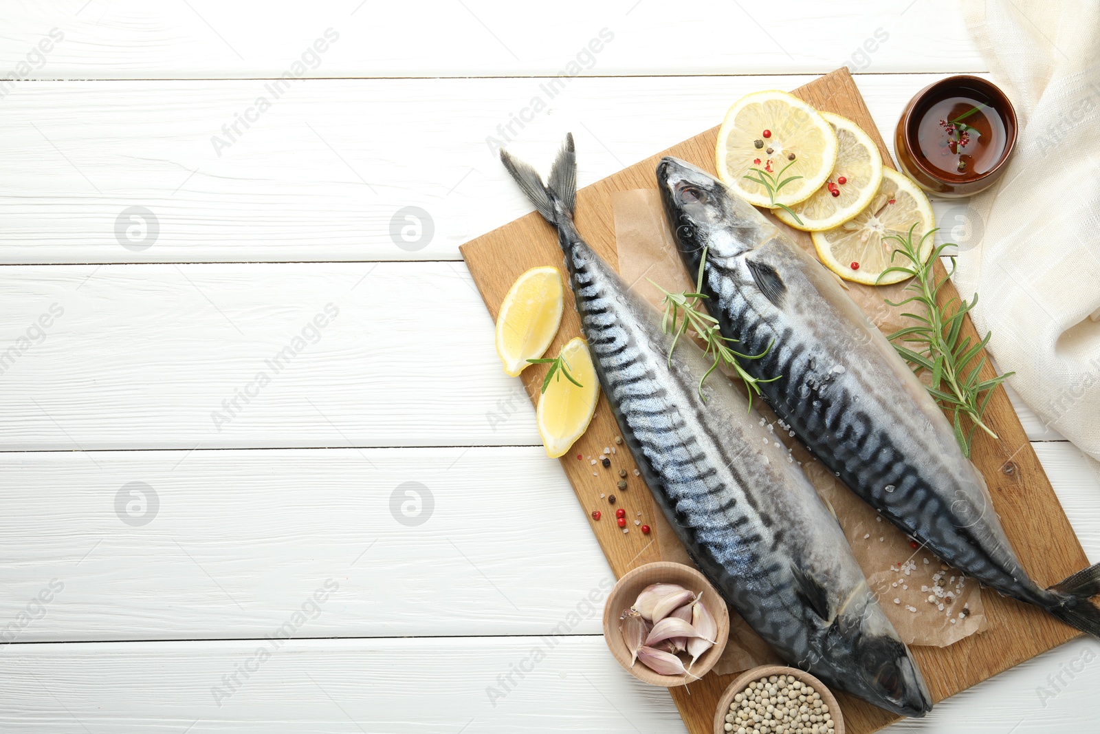 Seafood delicacies. Fresh raw mackerels and spices on white wooden table, flat lay. Space for text Photo of Seafood delicacies. Fresh raw mackerels and spices on white wooden table, flat lay. Space for text
