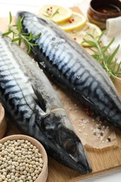 Photo of Fresh raw mackerels and spices on table, closeup. Seafood delicacies
