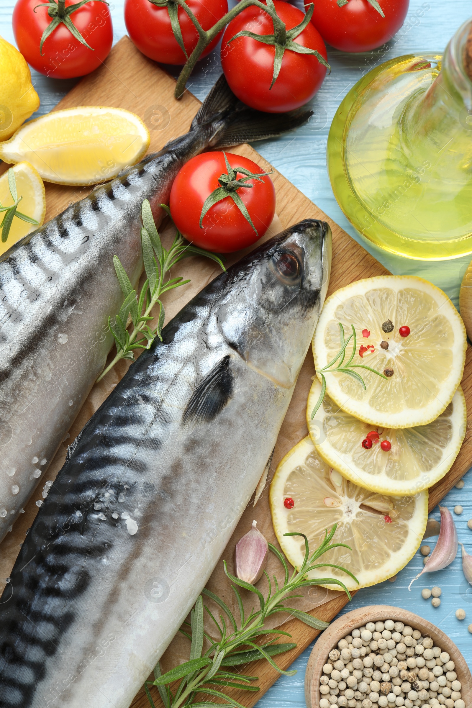 Fresh raw mackerels and spices on light blue wooden table, flat lay. Seafood delicacies Photo of Fresh raw mackerels and spices on light blue wooden table, flat lay. Seafood delicacies