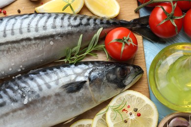 Photo of Fresh raw mackerels and spices on light blue wooden table, flat lay. Seafood delicacies