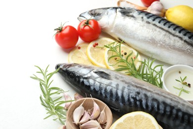 Photo of Fresh raw mackerels and spices on white table, closeup. Seafood delicacies