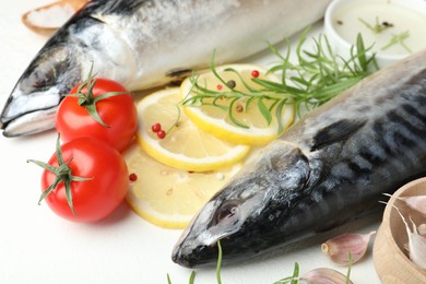 Photo of Fresh raw mackerels and spices on white table, closeup. Seafood delicacies