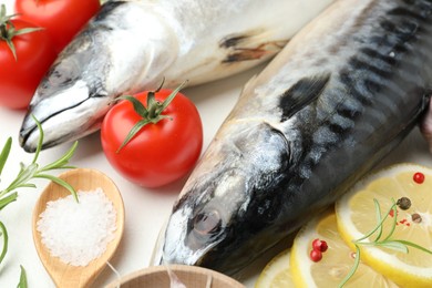 Photo of Fresh raw mackerels and spices on white table, closeup. Seafood delicacies