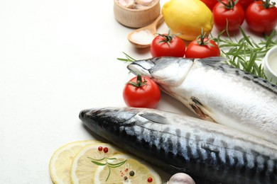 Photo of Seafood delicacies. Fresh raw mackerels and spices on white table, closeup. Space for text