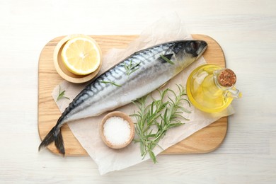 Photo of Fresh raw mackerel and spices on light wooden table, flat lay. Seafood delicacies