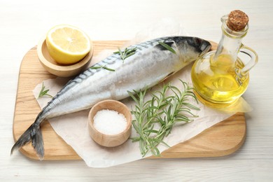 Photo of Fresh raw mackerel and spices on light wooden table, above view. Seafood delicacies