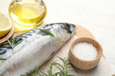 Photo of Fresh raw mackerel and spices on light wooden table, closeup. Seafood delicacies