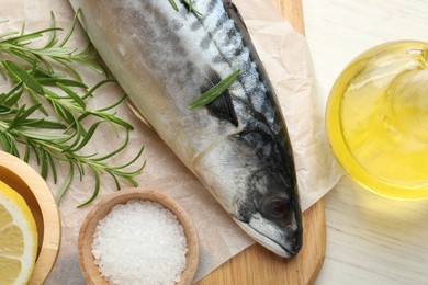 Photo of Fresh raw mackerel and spices on light wooden table, flat lay. Seafood delicacies