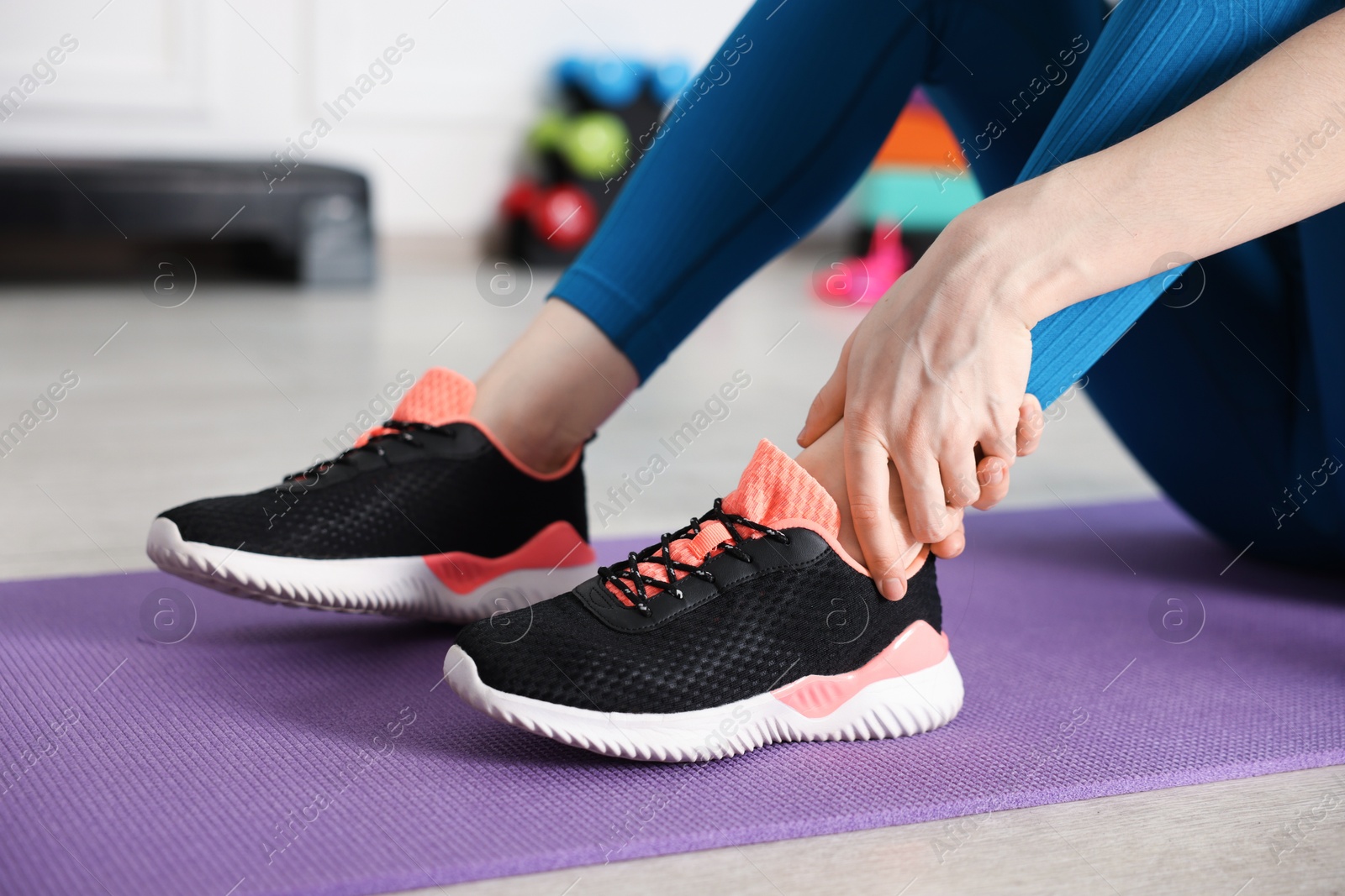 Sports injury. Young woman suffering from leg pain in fitness studio, closeup Photo of Sports injury. Young woman suffering from leg pain in fitness studio, closeup