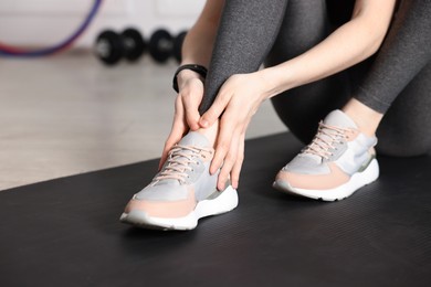Photo of Sports injury. Young woman suffering from leg pain in fitness studio, closeup