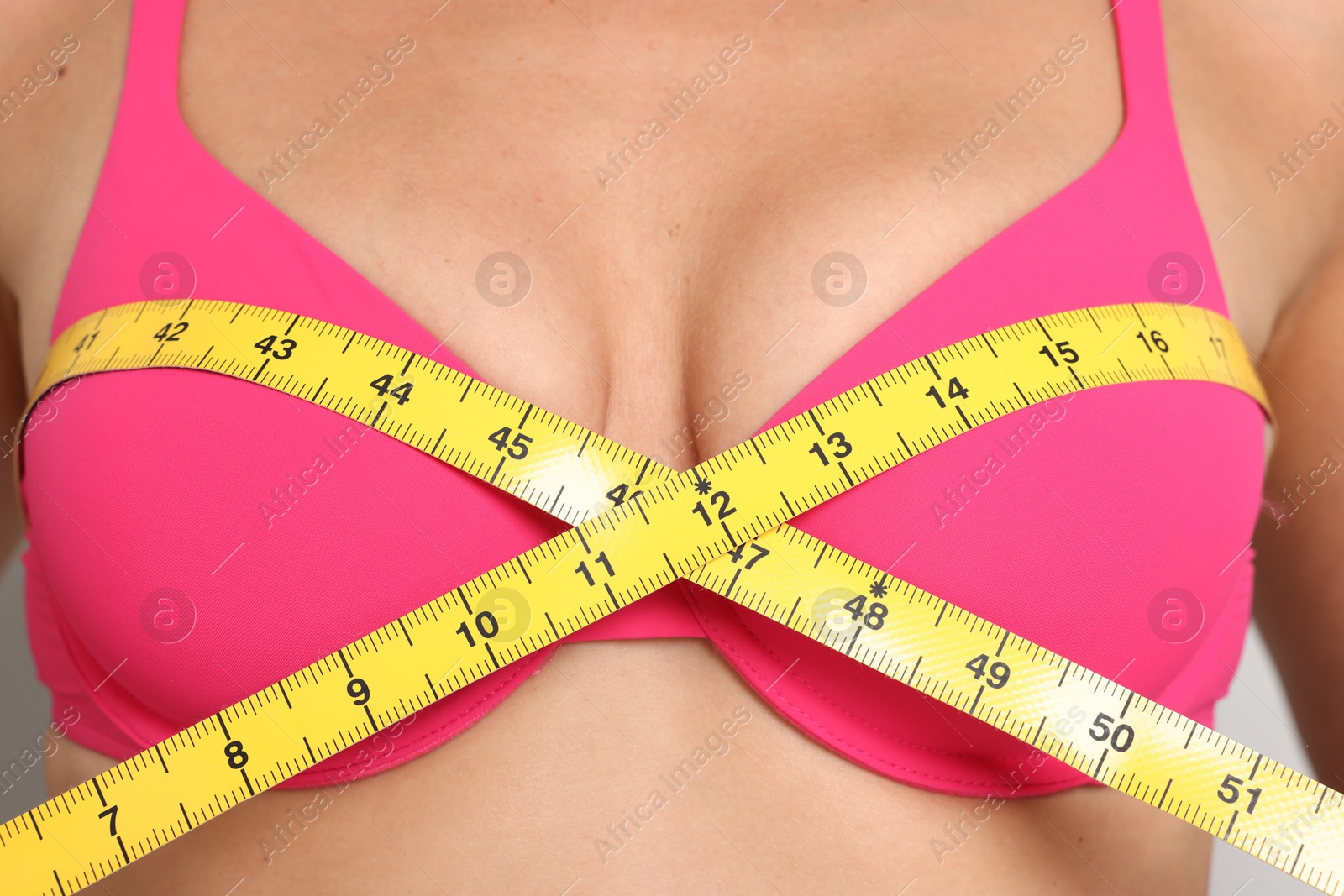 Photo of Woman in beautiful bra measuring breast circumference, closeup