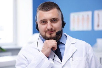 Photo of Doctor with headset in clinic. Online medical consultation