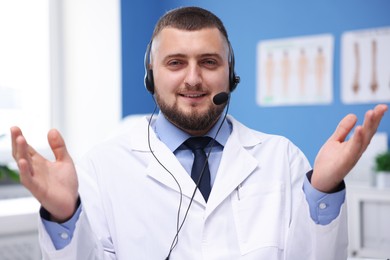 Photo of Doctor with headset in clinic. Online medical consultation