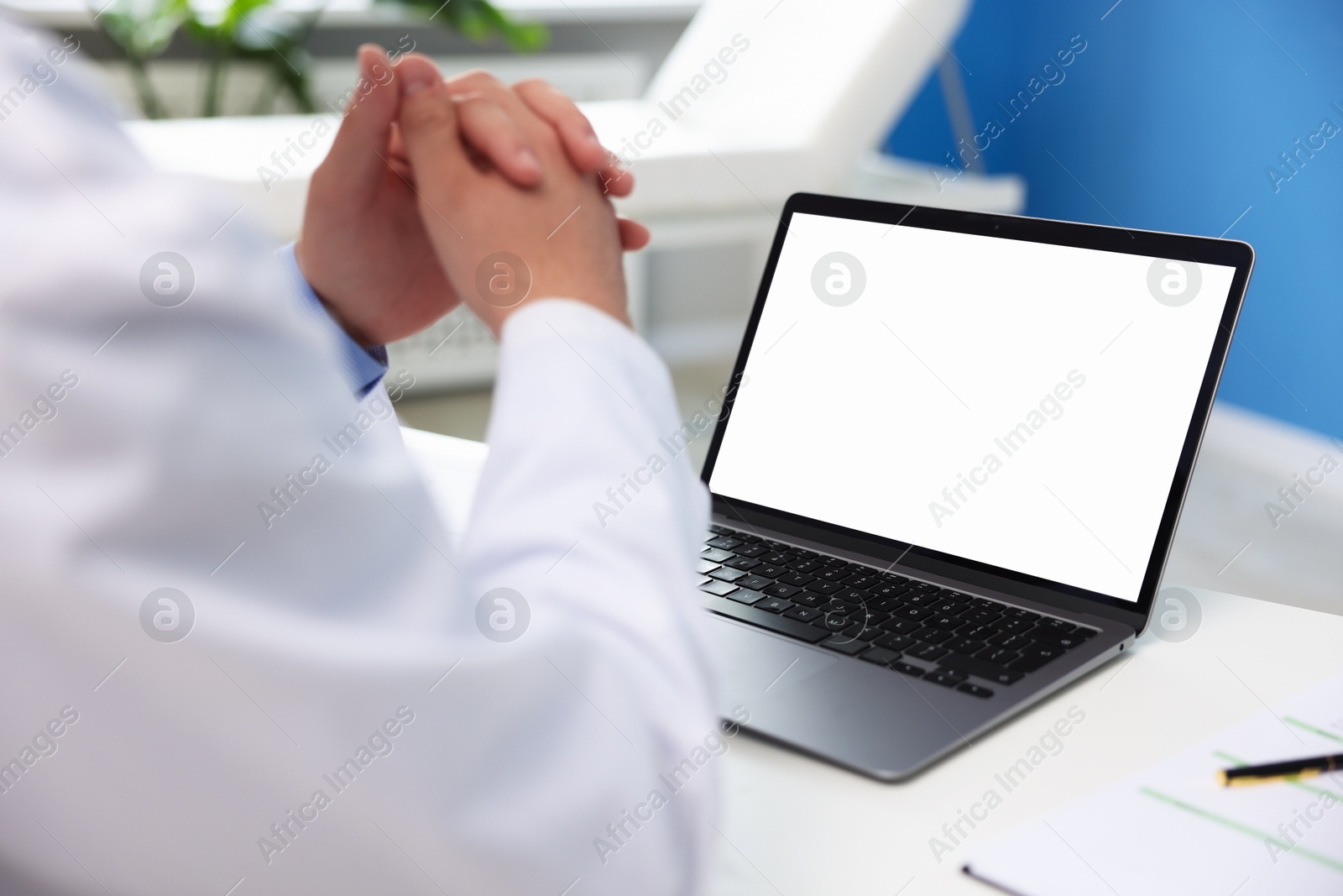 Doctor using laptop in clinic, closeup. Online medical consultation Photo of Doctor using laptop in clinic, closeup. Online medical consultation