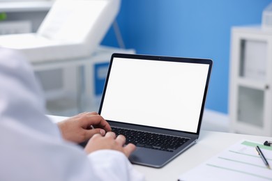 Photo of Doctor using laptop in clinic, closeup. Online medical consultation