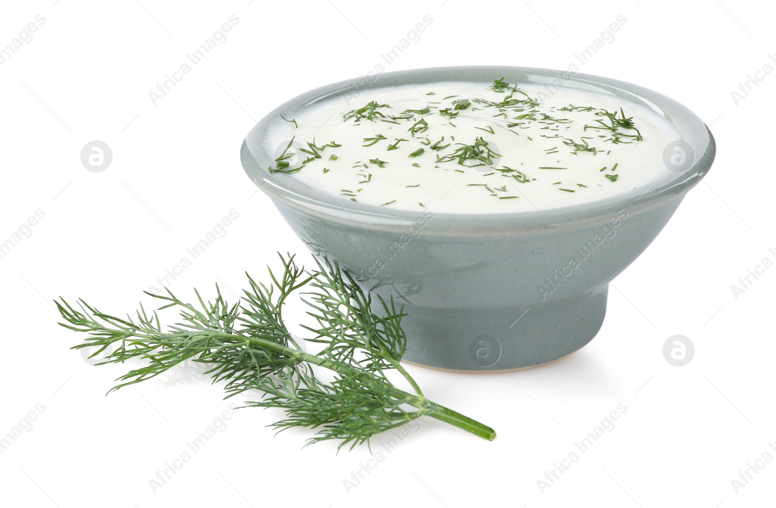 Delicious yogurt in bowl and dill isolated on white Photo of Delicious yogurt in bowl and dill isolated on white