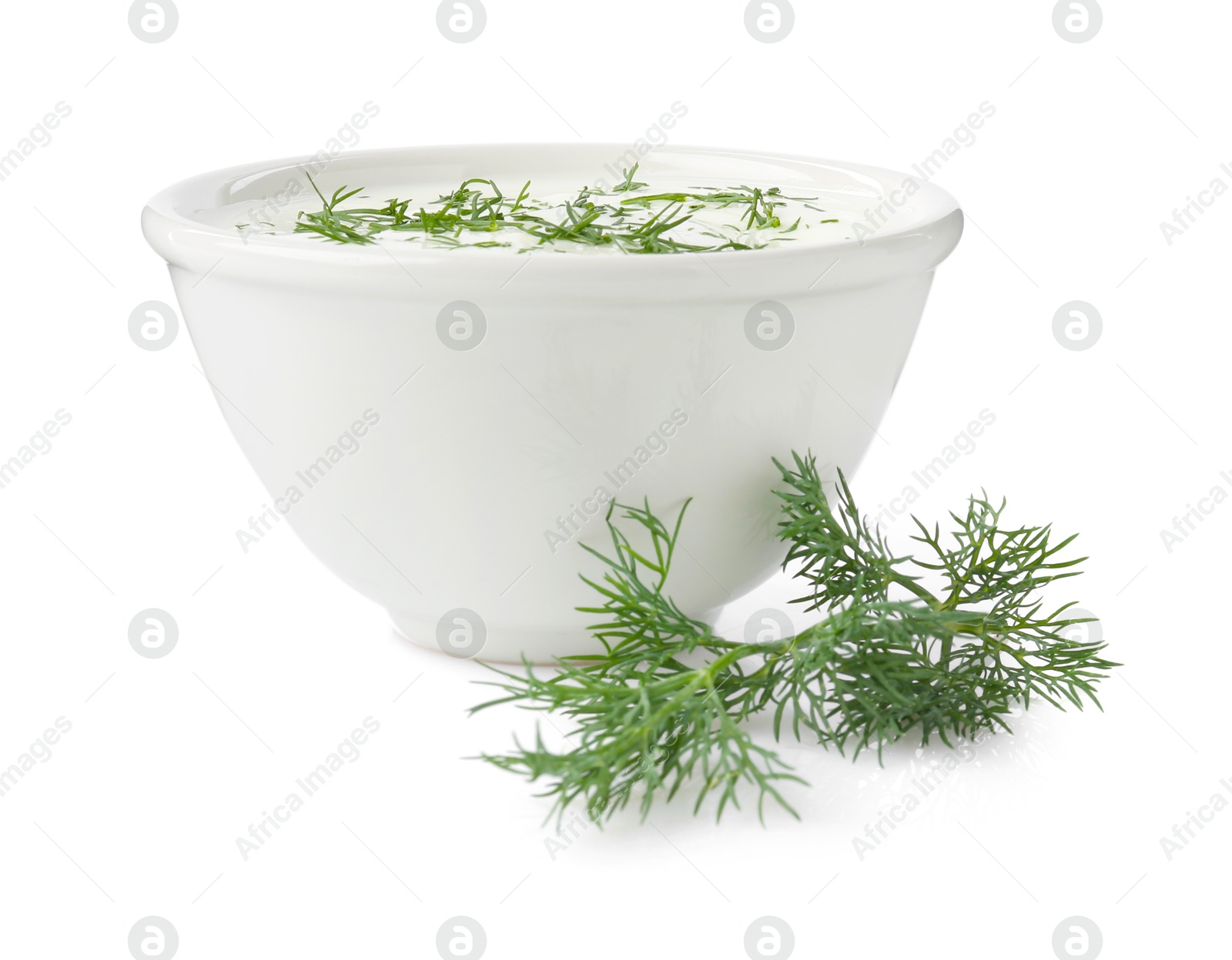 Delicious yogurt in bowl and dill isolated on white Photo of Delicious yogurt in bowl and dill isolated on white