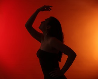 Photo of Silhouette of woman posing on red gradient background