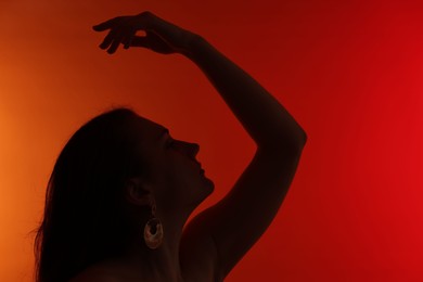 Photo of Silhouette of woman posing on red gradient background, space for text