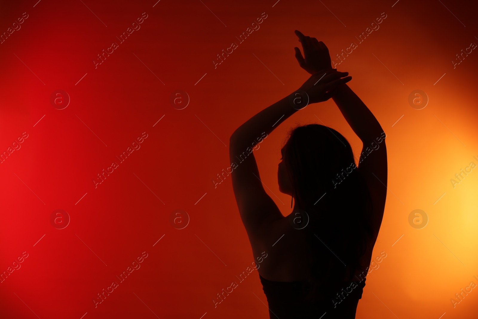 Photo of Silhouette of woman posing on red gradient background, back view. Space for text