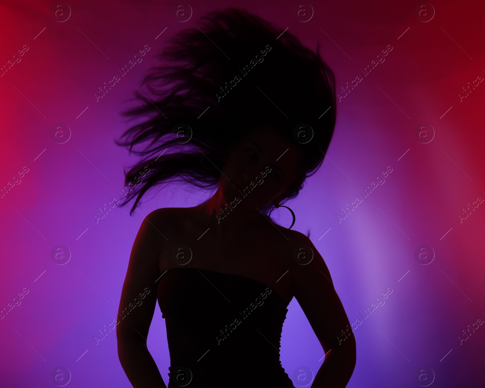 Silhouette of woman posing in neon lights on color background Photo of Silhouette of woman posing in neon lights on color background