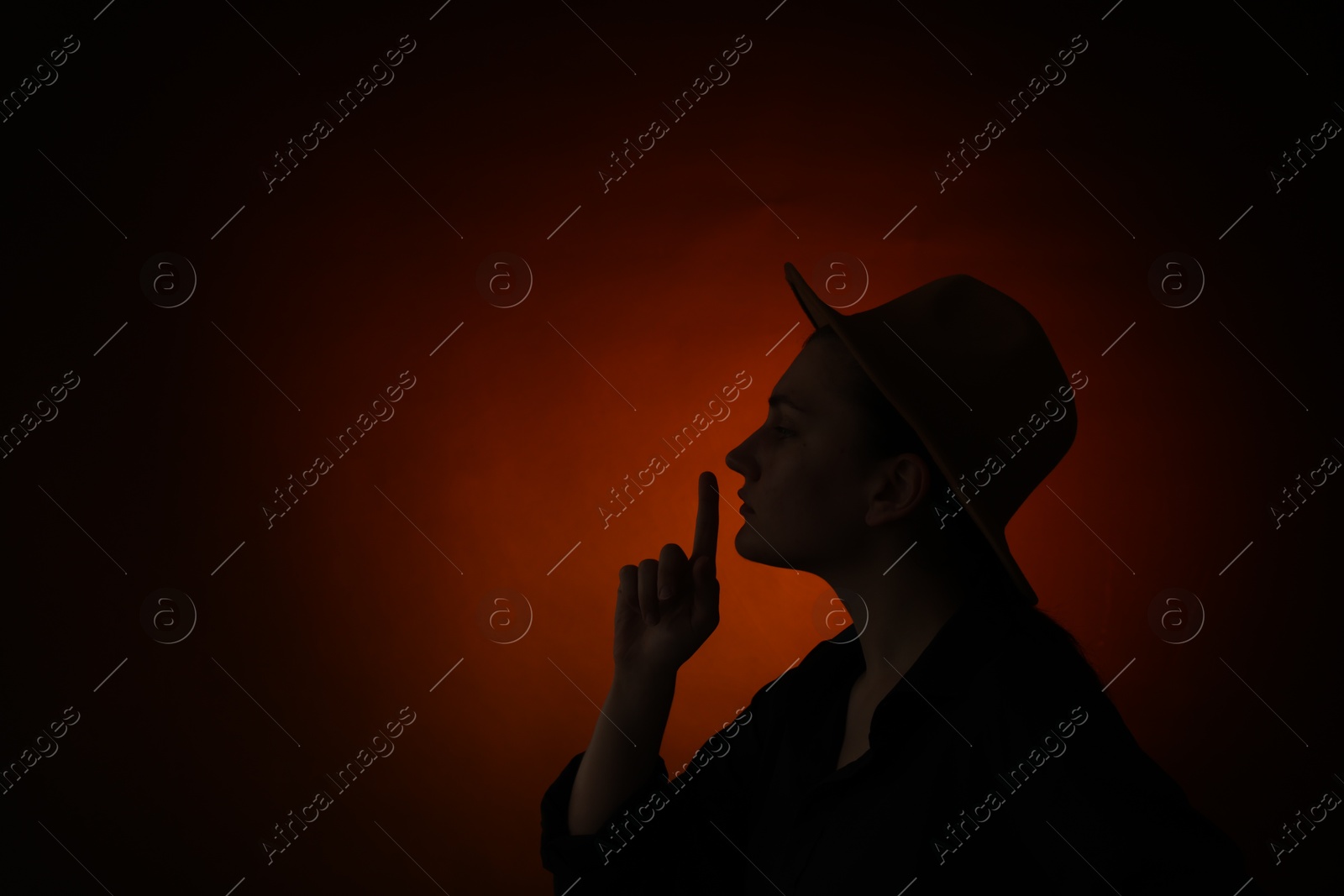 Silhouette of woman making silent gesture on dark gradient background, space for text Photo of Silhouette of woman making silent gesture on dark gradient background, space for text