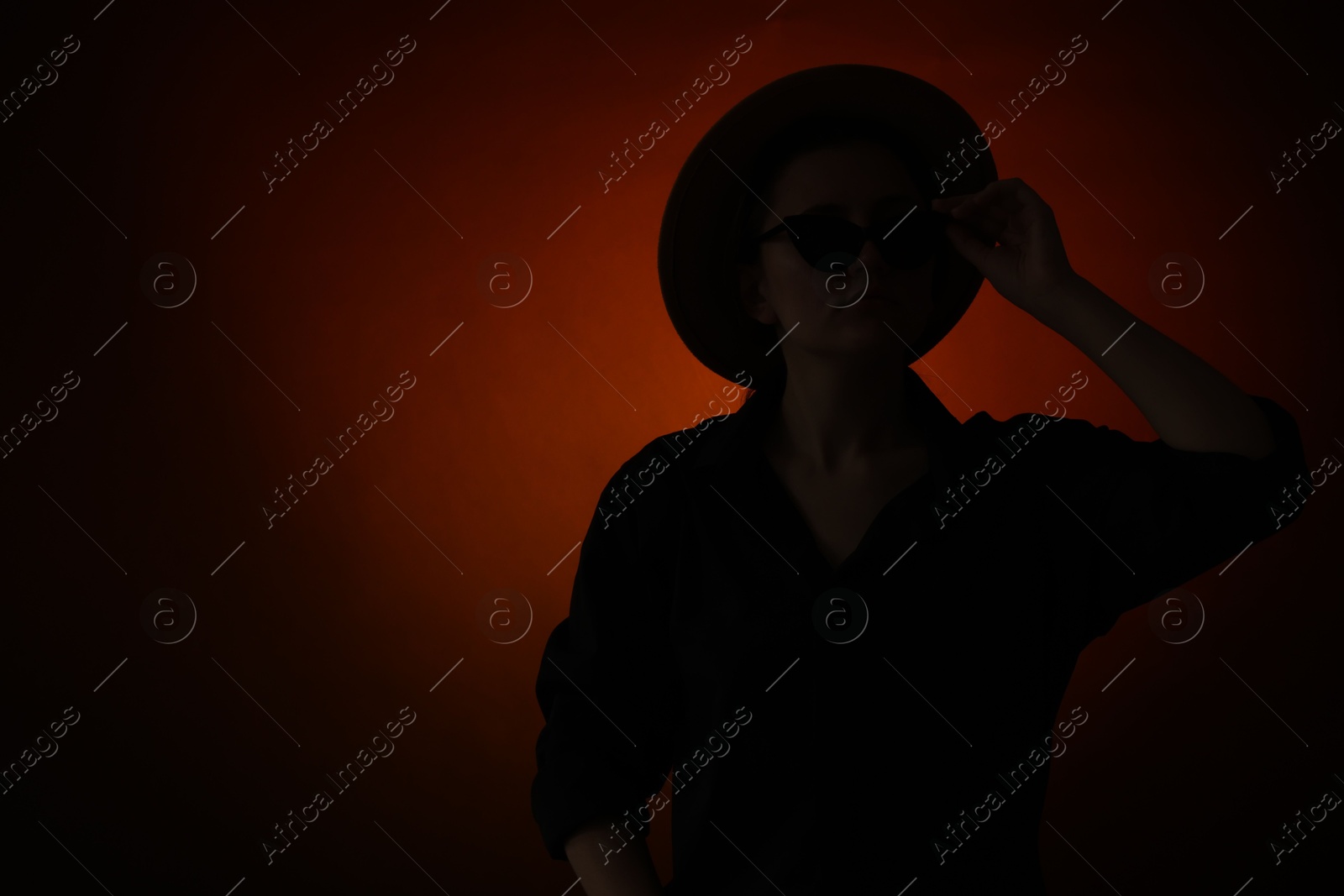 Photo of Silhouette of woman posing on dark gradient background, space for text