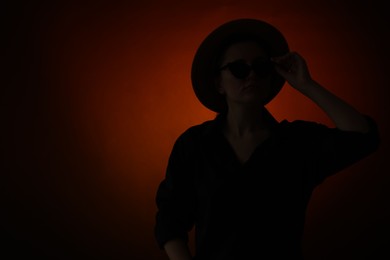 Photo of Silhouette of woman posing on dark gradient background, space for text
