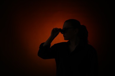 Photo of Silhouette of woman posing on dark gradient background, space for text