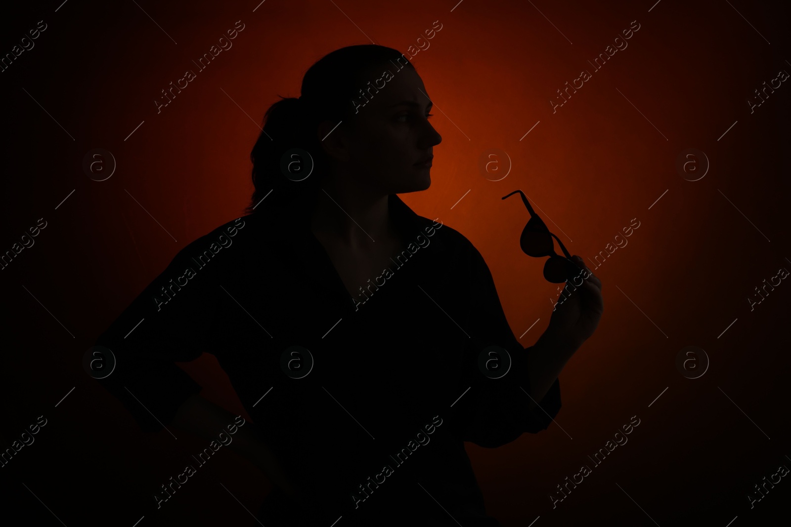 Photo of Silhouette of woman with sunglasses on dark gradient background
