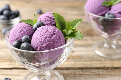 Photo of Tasty sorbet with blueberries and mint in dessert bowls on wooden table, closeup