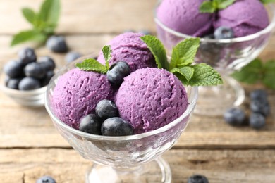 Photo of Tasty sorbet with blueberries and mint in dessert bowls on wooden table, closeup