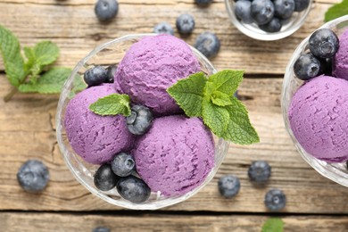 Photo of Tasty sorbet with blueberries and mint in dessert bowl on wooden table, flat lay