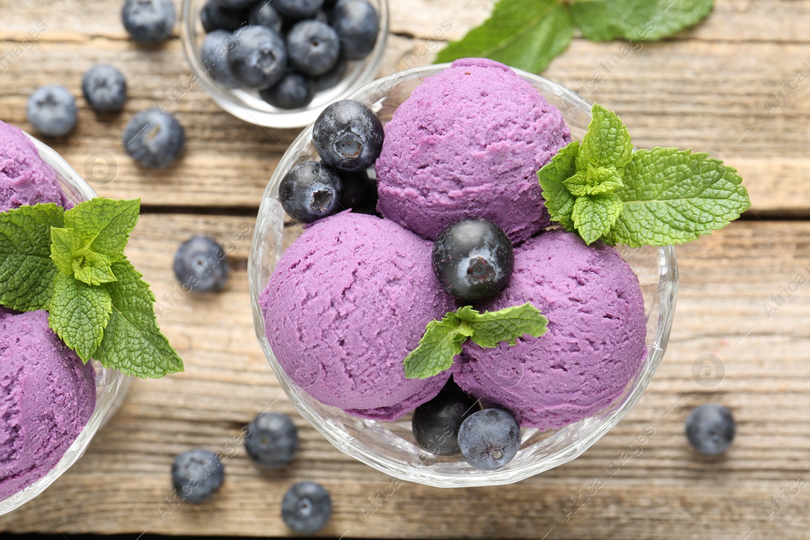 Tasty sorbet with blueberries and mint in dessert bowl on wooden table, flat lay Photo of Tasty sorbet with blueberries and mint in dessert bowl on wooden table, flat lay
