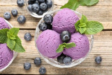 Photo of Tasty sorbet with blueberries and mint in dessert bowl on wooden table, flat lay