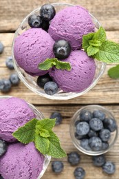 Photo of Tasty sorbet with blueberries and mint in dessert bowls on wooden table, flat lay