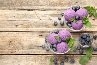 Photo of Tasty sorbet with blueberries and mint in dessert bowls on wooden table, flat lay. Space for text