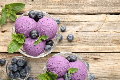 Photo of Tasty sorbet with blueberries and mint in dessert bowls on wooden table, flat lay. Space for text