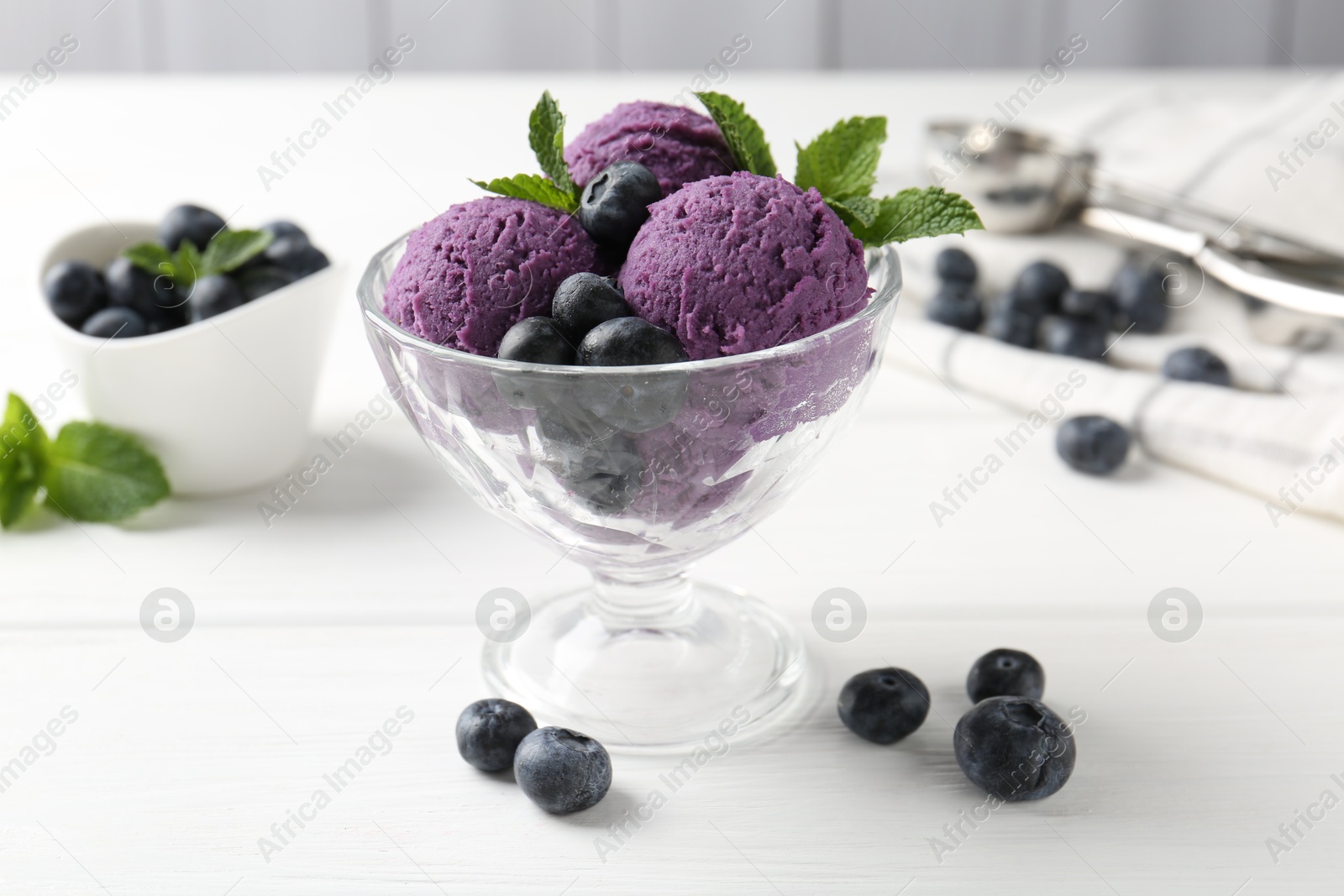 Tasty sorbet with blueberries and mint in dessert bowl on white wooden table, closeup Photo of Tasty sorbet with blueberries and mint in dessert bowl on white wooden table, closeup