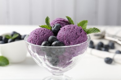 Photo of Tasty sorbet with blueberries and mint in dessert bowl on white table against grey background, closeup