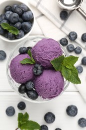 Photo of Tasty sorbet with blueberries and mint in dessert bowl on white wooden table, flat lay
