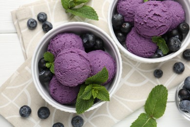 Photo of Tasty sorbet with blueberries and mint in bowls on white wooden table, flat lay