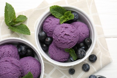 Photo of Tasty sorbet with blueberries and mint in bowls on white wooden table, top view