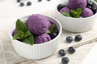 Photo of Tasty sorbet with blueberries and mint in bowls on white table, closeup