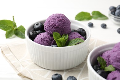Photo of Tasty sorbet with blueberries and mint in bowls on white table, closeup