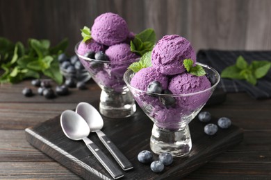 Photo of Tasty sorbet with blueberries and mint in dessert bowls on wooden table, closeup