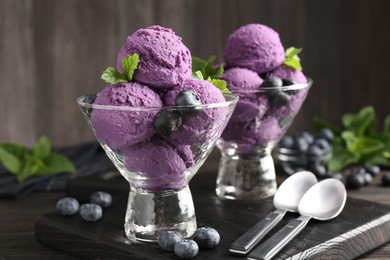 Photo of Tasty sorbet with blueberries and mint in dessert bowls on wooden table, closeup
